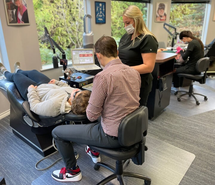 Team member and Dr. Ward examining patient's teeth